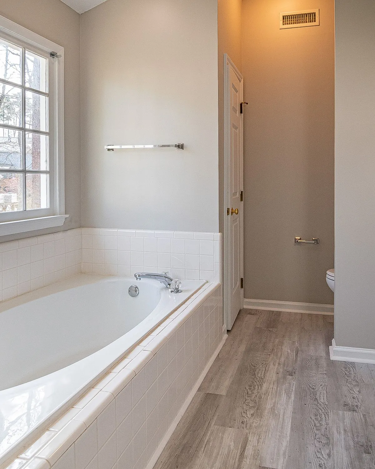 A bright, clean bathroom with a soaking tub and a window, for bathroom mold inspection in Falls Church, VA