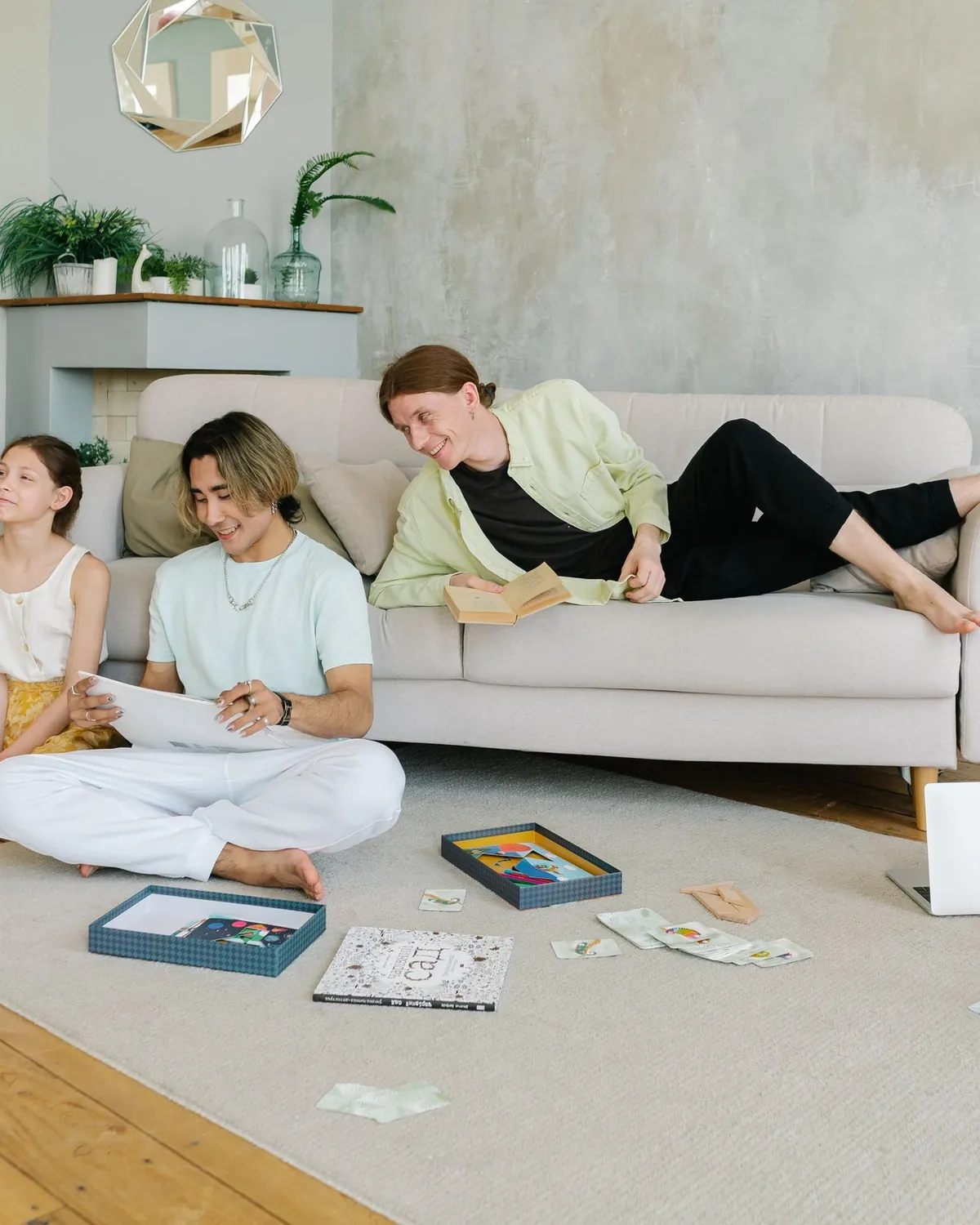 A family relaxing in a bright living room, some on the sofa and some on the floor, for crawl space mold inspection in Falls Church, VA