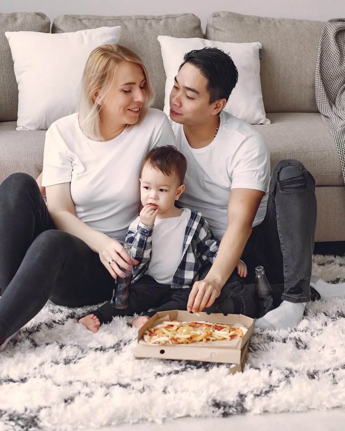 Parents and their toddler sitting together on a soft rug at home, for crawl space mold removal in Falls Church, VA