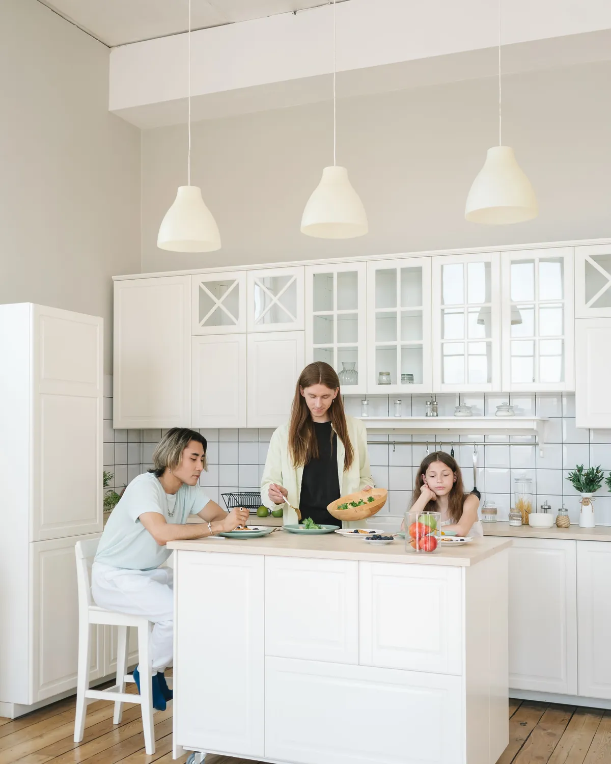 A family preparing a meal together in a bright white kitchen, for mold damage restoration in Falls Church, VA