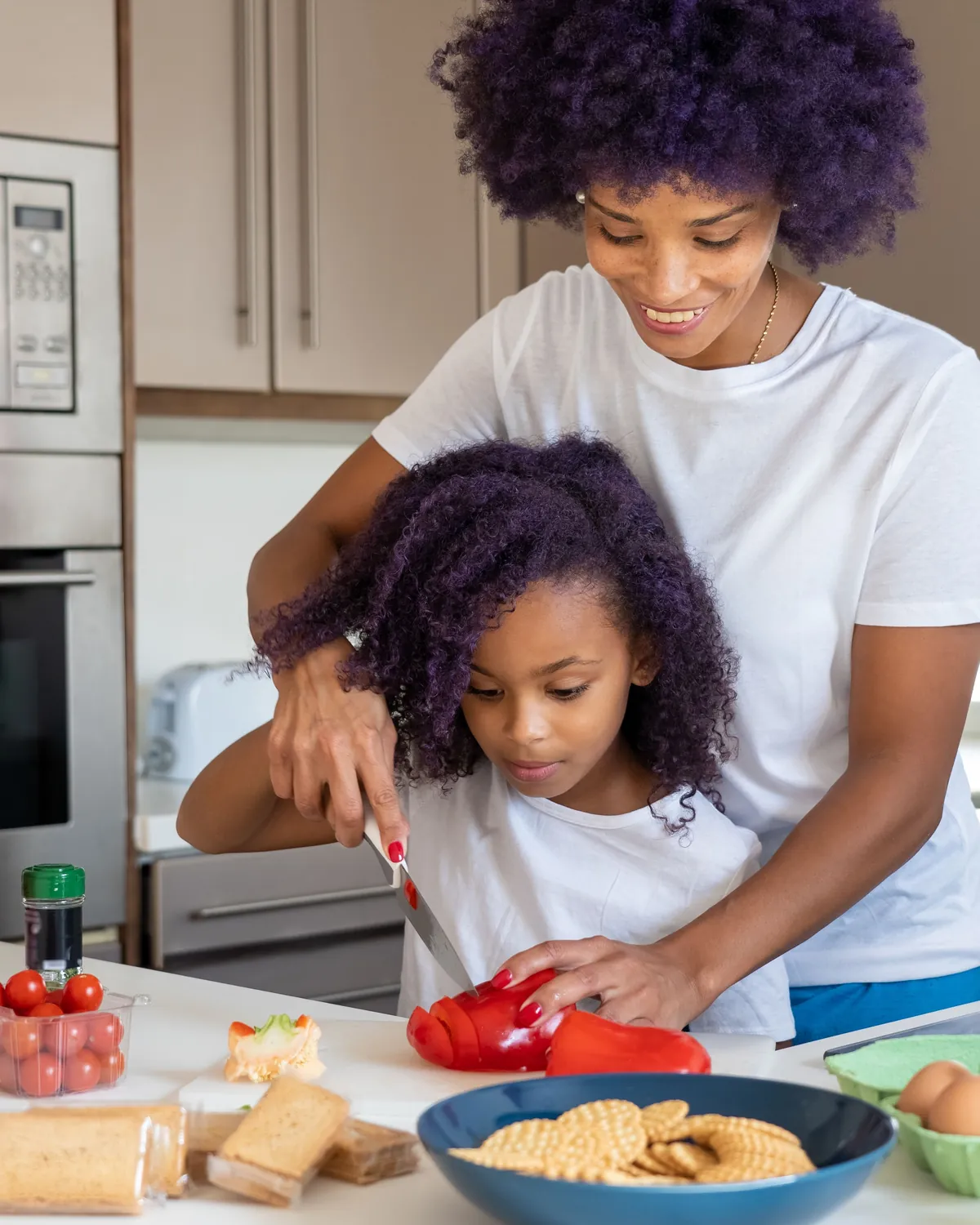 A mother and her daughter chopping vegetables together in a kitchen, for mold testing in Falls Church, VA
